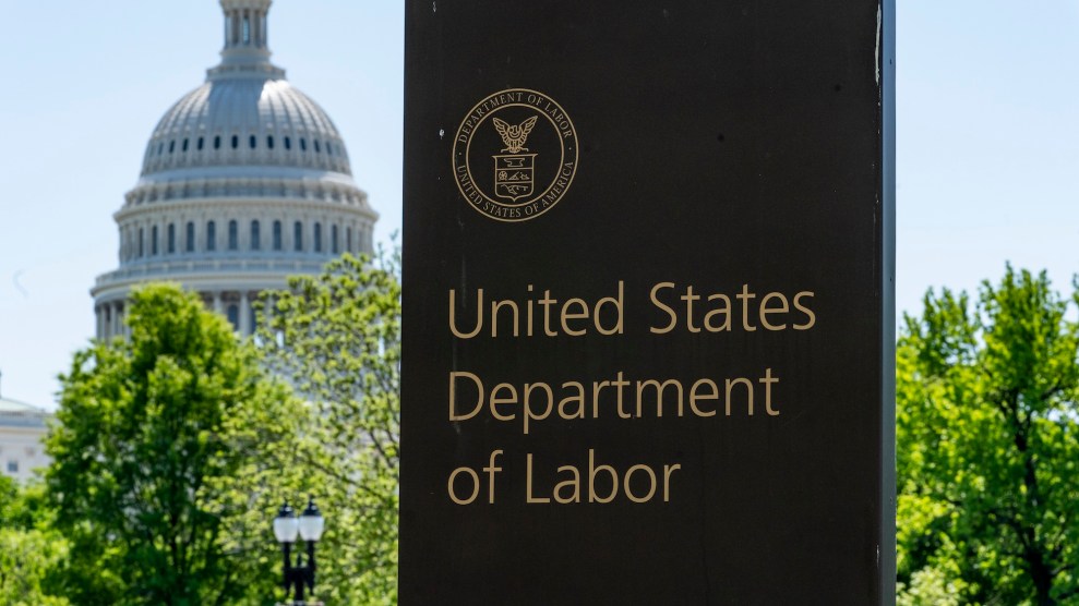 A sign in marble that says US Department of Labor on it with the Capitol building in the background.